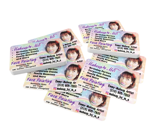 Multiple business cards for a makeup artist on a wooden surface
